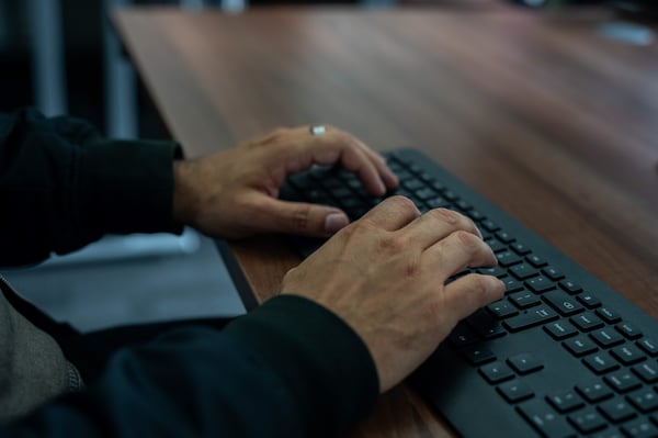 Individual using a keyboard at a computer.