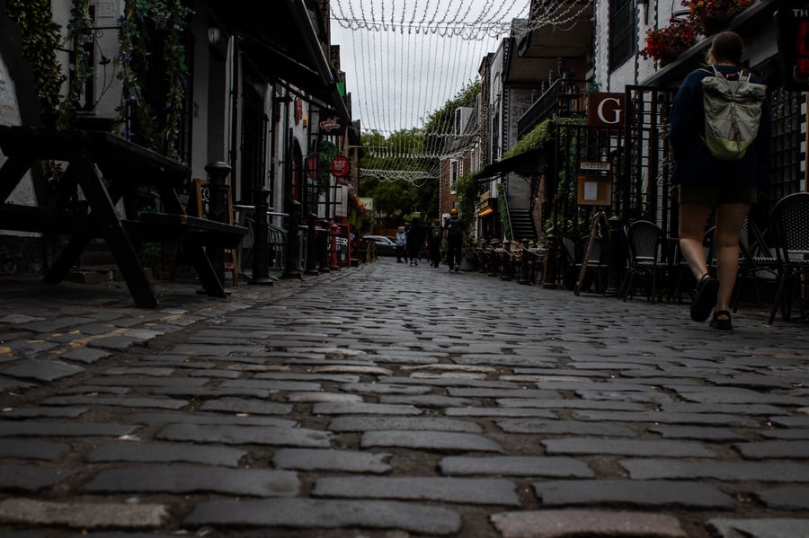 Cobblestone street with shops on either side