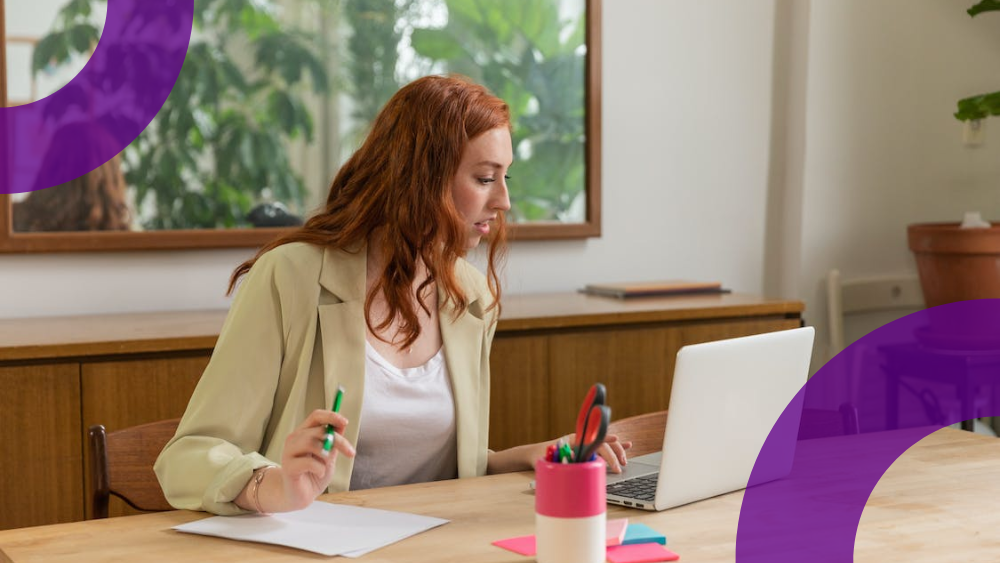 What's New in Microsoft 365 May 2023 - Woman sitting at desk looking at laptop